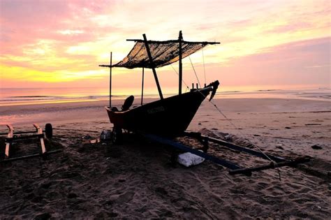 Premium Photo | A boat on the beach at sunset with a sunset in the ...