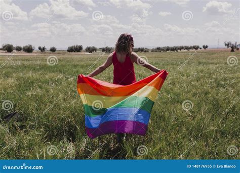 Woman Holding The Gay Rainbow Flag On A Green Meadow Outdoors Happiness Freedom And Love