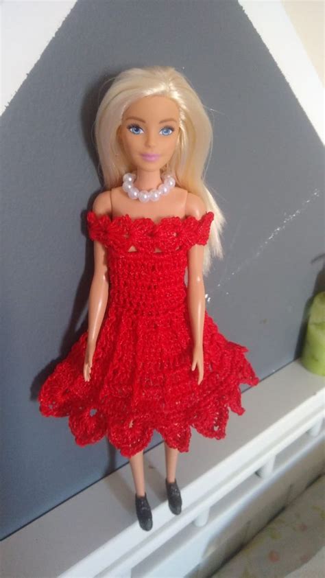 The Doll Is Wearing A Red Dress And Pearls