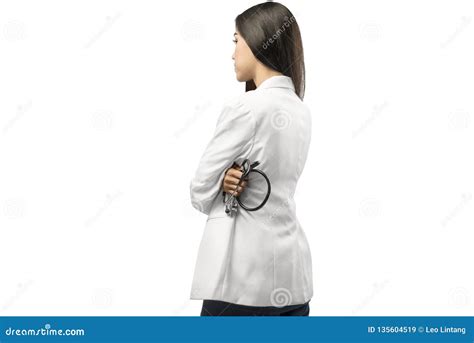 Rear View Of Asian Doctor Woman In White Coat Holding Stethoscope Stock