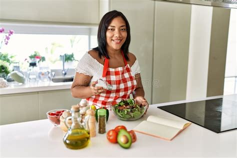 Hispanic Brunette Woman Seasoning Green Salad At The Kitchen Stock Photo Image Of Lettuce
