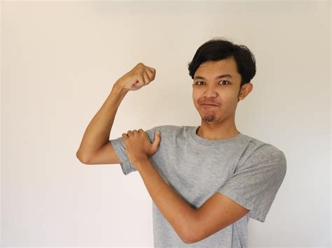 Premium Photo Excited Asian Man Wearing A Grey Shirt Showing Strong