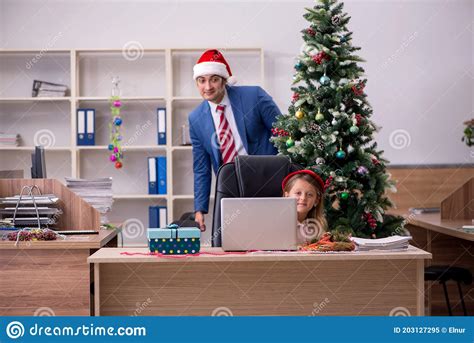 Young Male Employee Celebrating Christmas At Workplace With His Stock