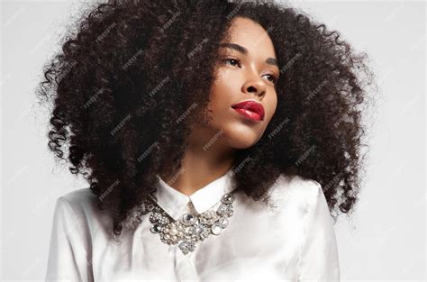 Femme Noire Regardant De Côté Avec Une Peau Idéale Et Des Cheveux Bouclés Photo Premium