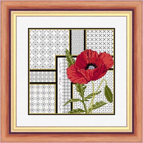 A Cross Stitch Pattern With Orange Flowers In A Wooden Frame On A White