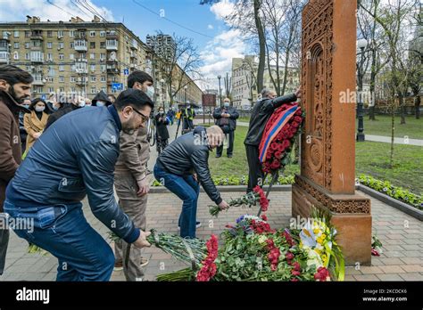 People leave flowers under a khachkar, a memorial stone stele of armenian culture, during the ...