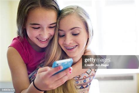 Two Preteen Girls Sharing Earphones Photos And Premium High Res