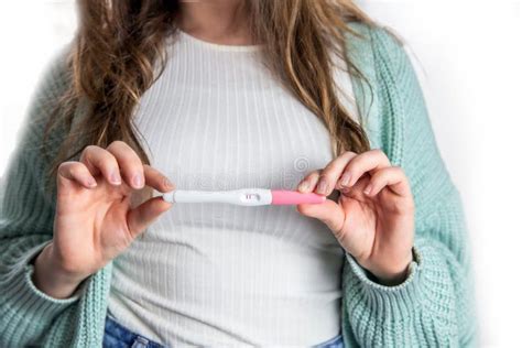 Happy Young Woman Holding A Positive Pregnancy Test Close Up Bright