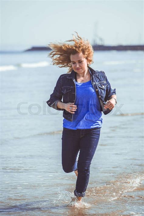 Ung kvinde gå alene på stranden Stock foto Colourbox