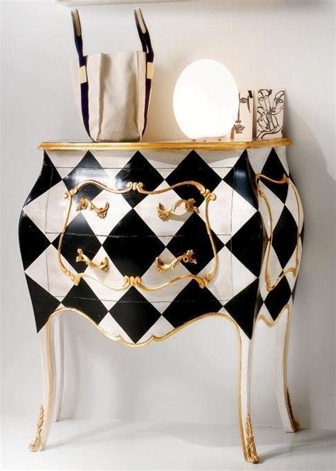 A Black And White Checkered Dresser With Gold Trim On It S Legs