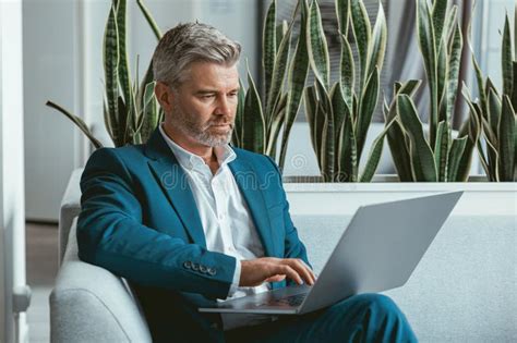Busy Mature Businessman Workingon Laptop While Sitting In Modern Coworking Stock Image Image