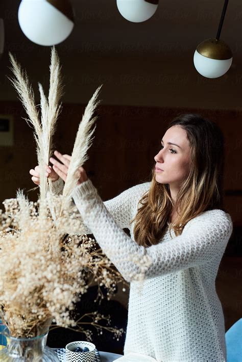 Woman Arranging Dried Plants In Vase By Stocksy Contributor Guille