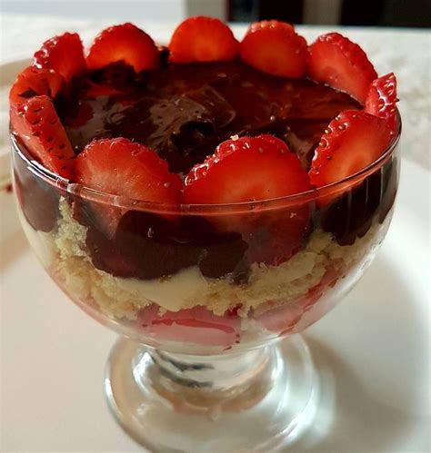 A Dessert With Strawberries And Chocolate Sauce In A Glass Dish On A