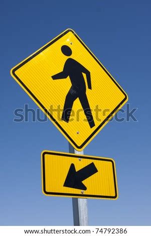 Close View Of Yellow And Black Pedestrian Walkway Sign Agianst A Blue ...