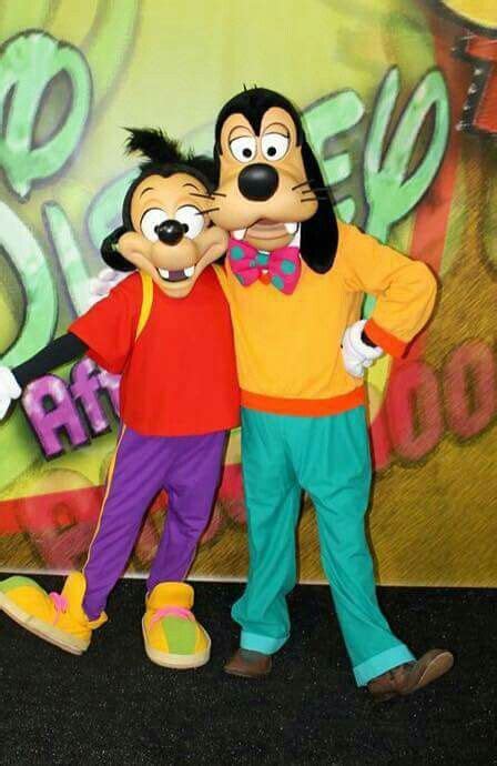 Goofy And Pluto Pose For A Photo In Front Of A Backdrop At The Disney Parks