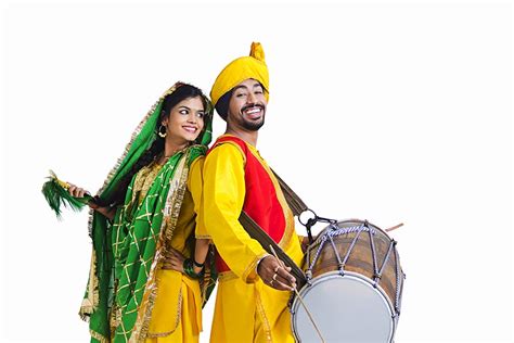 Punjabi Couple Playing Dhol And Dancing Bhangra On Lohri Or Vaisakhi Festival