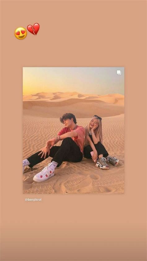 Two People Are Sitting In The Sand With Hearts On Their Feet And One