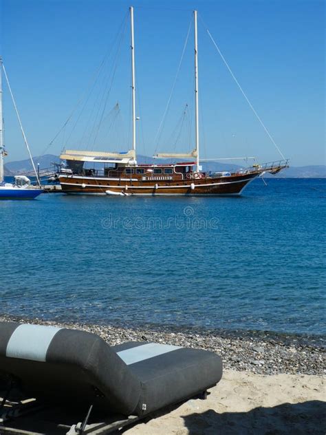 Barco De Vela De Madera Atracado En Un Mar Azul Transparente Frente A