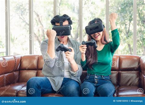 Young Couple Having Fun While Playing Virtual Reality Game Together In