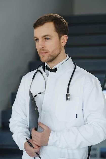 Premium Photo Portrait Of Smiling Doctor In Uniform Standing In