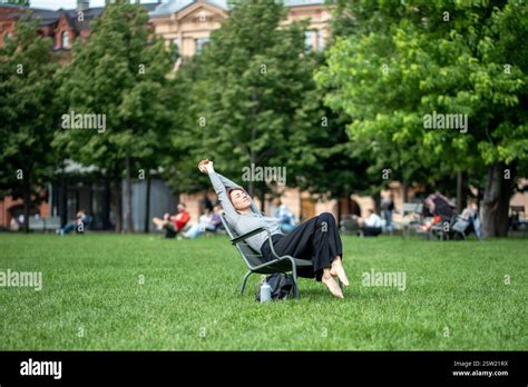 Laid Back Lazy And Drowsy Woman Stretching And Napping In Park Lounger During Hot Summer Day