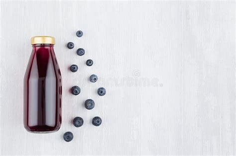 Fresh Violet Blueberry Juice In Glass Bottle With Blank Label Template With Glass Berries On