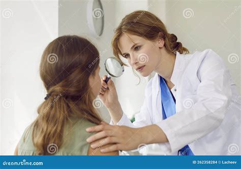 Professional Dermatologist Examines Face Of Teenage Girl With