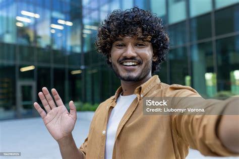 Portrait Of A Young Indian Male Student Standing Outside Campus Talking