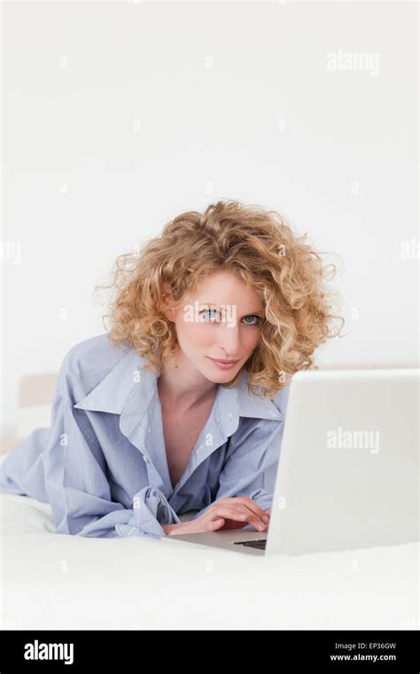 Good Looking Blonde Female Relaxing With Her Laptop While Lying On Her Bed Stock Photo Alamy