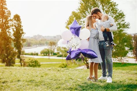 Eine junge und schöne blonde Mutter in einem blauen Kleid zusammen mit ihrem gutaussehenden