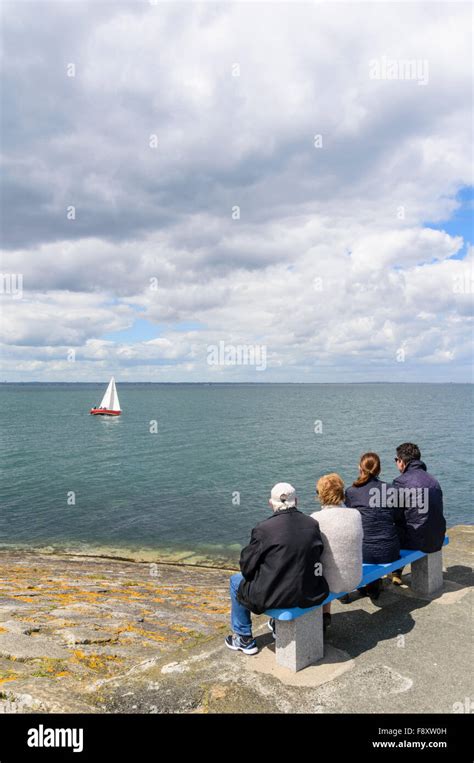 People Seated On A Bench At The End Of Dun Laoghaire East Pier Dun