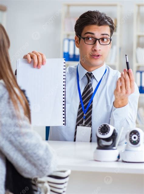 El Asistente De Ventas Mostrando Las Cámaras Al Cliente En La Tienda El