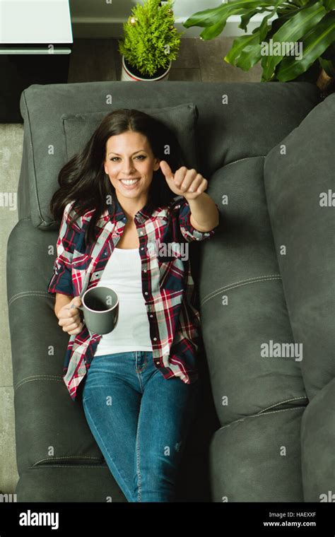 Attractive Brunette Girl Resting On The Sofa And Drinking A Cofee Stock Photo Alamy
