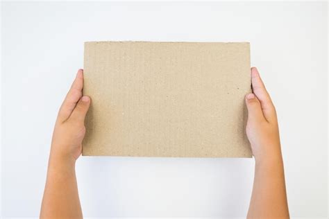 Premium Photo Hands Holding A Piece Of Cardboard Isolated On A White