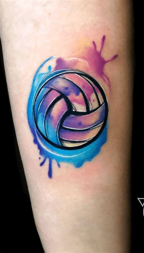 a colorful tattoo on the leg of a woman with an artistic blue and pink ...