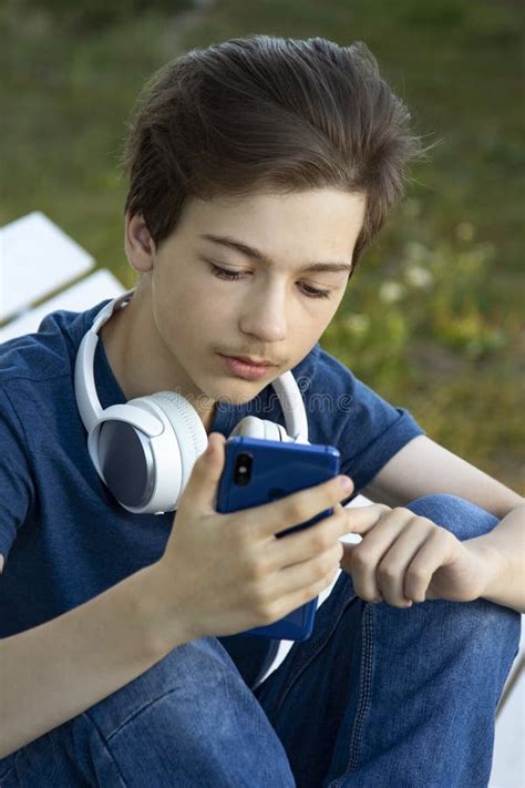 Adolescente Segurado Em Smartphone Manual Garoto Olha No Celular E