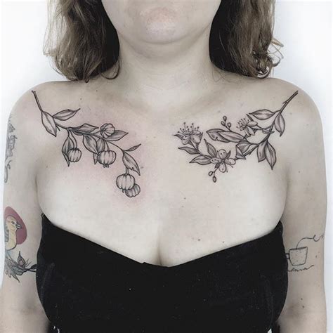 A Woman With Tattoos On Her Chest Posing For The Camera