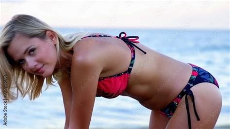 Woman In A Bikini Bending Over At The Beach With The Ocean In The Background Stock Video