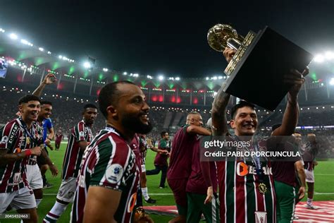 Fluminense players celebrate with the trophy after defeating Liga de ...