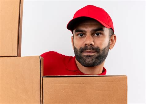 Free Photo Bearded Delivery Man In Red Uniform And Cap With Cardboard