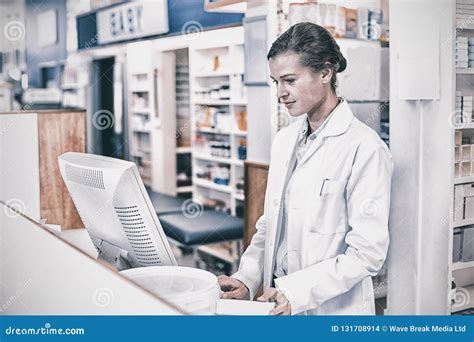 Pharmacist Making Prescription Record Through Computer Stock Photo