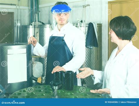 Male Employee Operating Machine At Sparkling Wine Factory Stock Photo