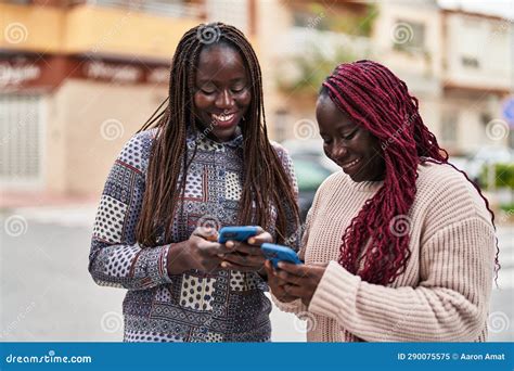 African American Women Friends Smiling Confident Using Smartphone At