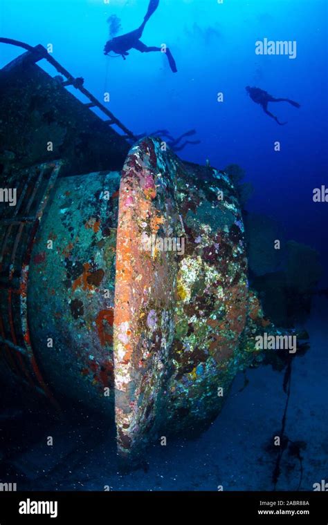 Scuba Divers Exploring A Large Underwater Shipwreck In Thailand Stock