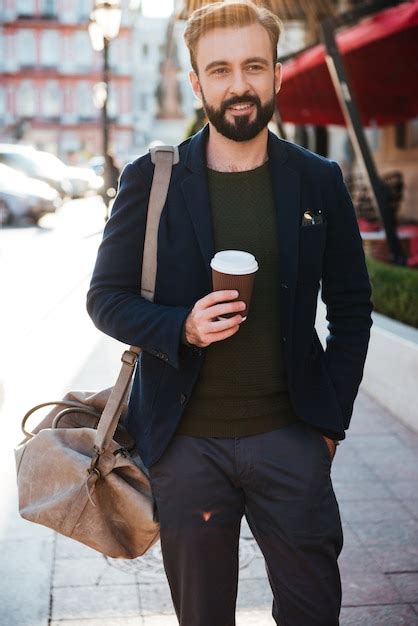 Retrato de un hombre barbudo sonriente tomando café Foto Gratis