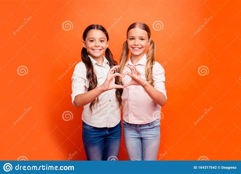 Portrait De Deux Jeunes Filles Joyeuses Debout Ensemble Font Des Doigts