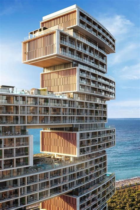 A Tall Building With Balconies On Top Of It Next To The Ocean In Front