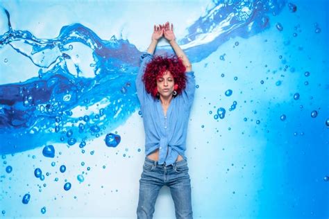 Retrato De Una Joven Latina Feliz Y Sonriente Con El Pelo Afro Rojo Apoyada En Un Fondo Azul Con