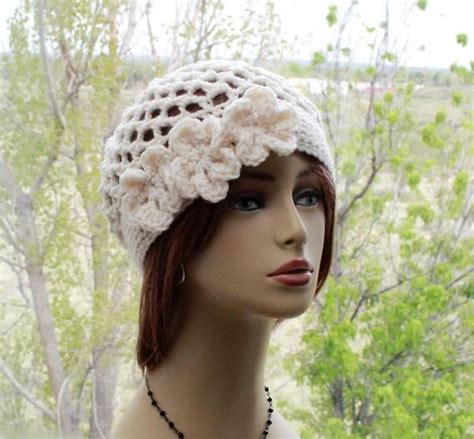 A Mannequin Head Wearing A White Crochet Hat With Flowers On It