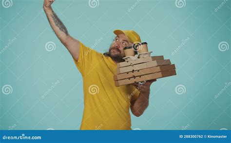 Delivery Man In Yellow Uniform Holding Pizza Boxes And Coffee Cup